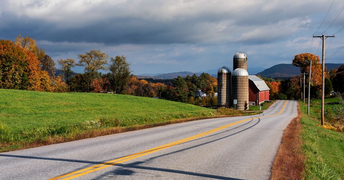 A Vermont farm with silos on a country road